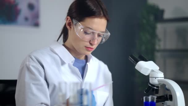 女微生物学家学生正在实验室里检查样品 — 图库视频影像
