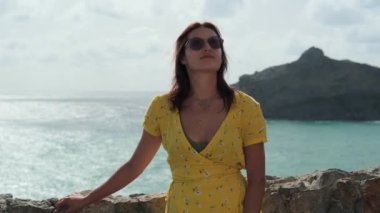 Deniz kıyısında yaz tatili, kadın gezgin güneşin tadını çıkarıyor.