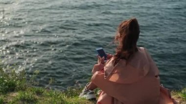 Yalnız bayan gezgin sosyal ağda sohbet etmek için akıllı telefon kullanıyor.