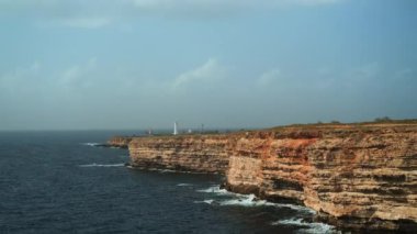 Kayalık pelerinli ve deniz fenerli deniz manzarası