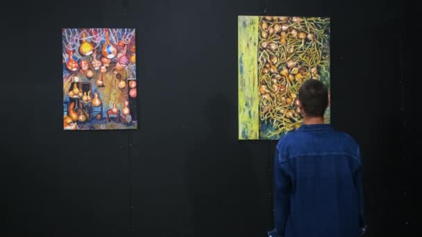 Jonge man geniet van moderne kunst werk van getalenteerde kunstenaar in galerie — Stockvideo