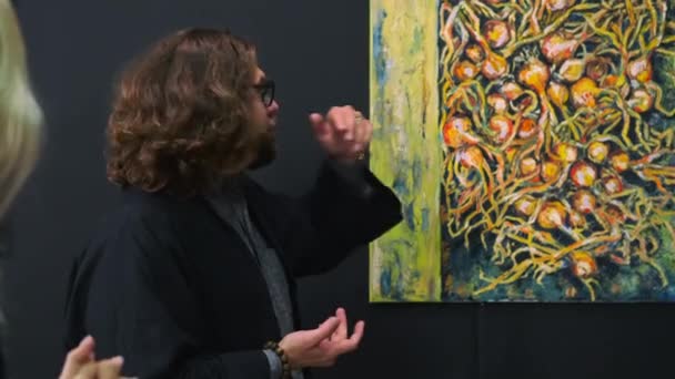 Krytyk sztuki opowiada o obrazie współczesnego artysty w muzeum, wycieczce artystycznej — Wideo stockowe