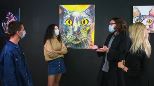 Mensen bezoeken tentoonstelling van kunstwerken van moderne kunstenaar tijdens pandemie van covid-19 — Stockvideo