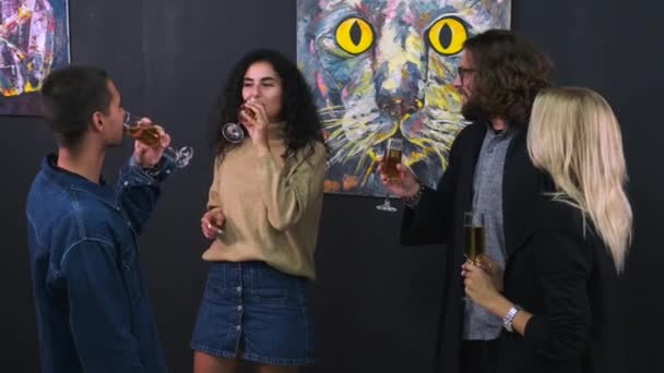 Przyjaciele rozmawiają o sztuce i piciu wina na wystawie — Wideo stockowe