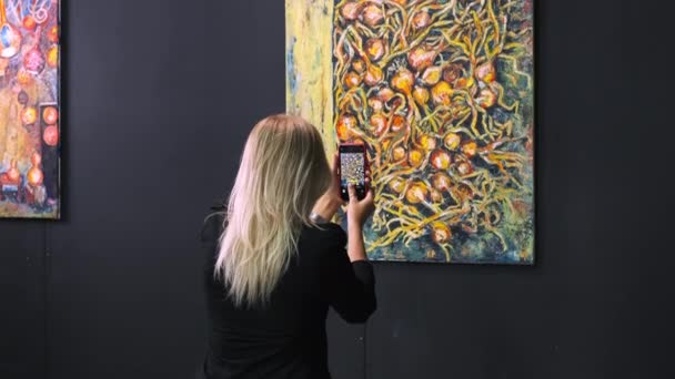 Amante del arte tomando fotos de pintura en la exposición — Vídeos de Stock