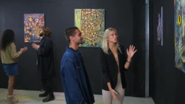 Gençler soyut resimlerle modern sanatın keyfini çıkarıyorlar.