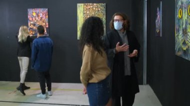 Resim galerisinin ziyaretçileri sanat hakkında konuşuyorlar.