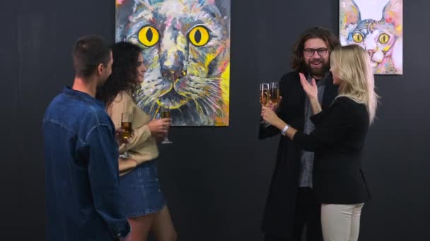 Company of young people are visiting exhibition of trendy artist in gallery and drinking champagne — Stock Video