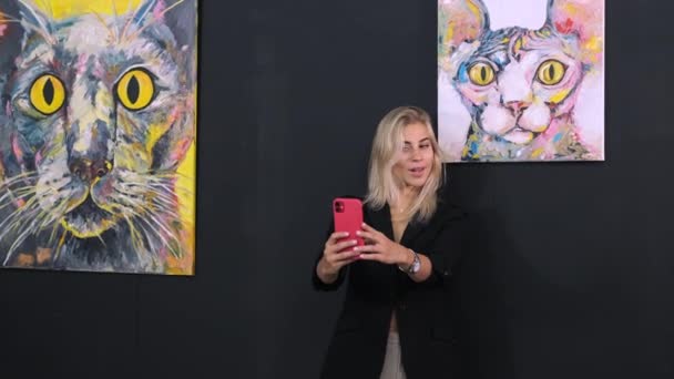 Jong grappig dame is het nemen van selfie met de smartphone in modern museum, poseren voor camera — Stockvideo