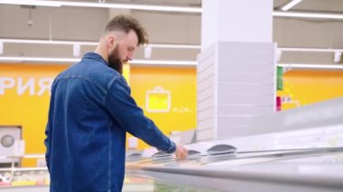 Süpermarketten donmuş sebze alan adam.