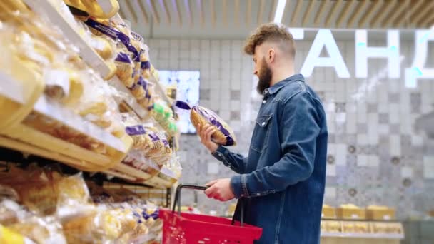 Чоловічий гість купує хліб у хлібопекарні в супермаркеті — стокове відео