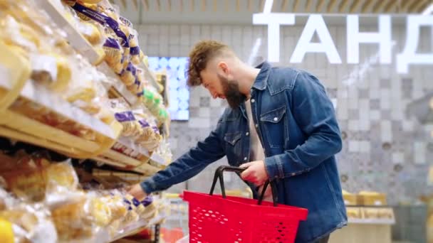 Man buyer choosing fresh and tasty bread in the grocery — Stock Video