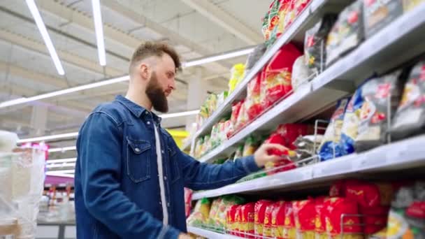 Férfi vevő vásárol a boltban, és figyelembe tészta — Stock videók
