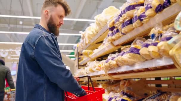 Homme achetant du pain au supermarché après avoir vérifié la date limite de vente — Video