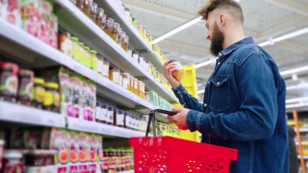 Muž kupující džem v supermarketu — Stock video