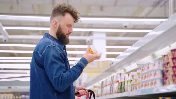 Hombre haciendo compras en el departamento de productos lácteos — Vídeos de Stock