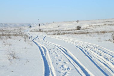 Karda yolu olan bir kış manzarası.