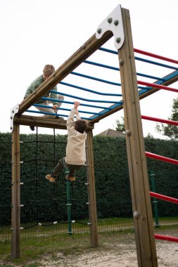 İki çocuk oyun parkında oyun saatinin keyfini çıkarıyorlar.