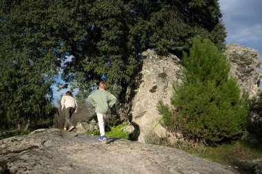 Ormanda yürüyen iki çocuk, doğayı keşfediyor.
