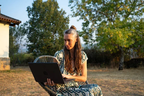 Kırsal alanda çalışırken dizüstü bilgisayara odaklanan bir kadın