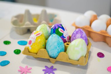 Renkli paskalya yumurtaları, tavşan çıkartmaları ve simleriyle kutlamaya hazır bir kutuda sergileniyor.