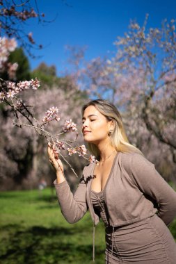 Madrid, İspanya 'daki Quinta de los molinos parkında badem çiçeklerinin kokusunun tadını çıkaran bir model.