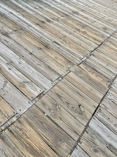 Tahtalardan yapılmış eski ahşap döşemeler farklı açılarda yerleştirilmiş. Yukarıdan aşağıya manzara, çivi bolluğu ve doğal ahşap doku.