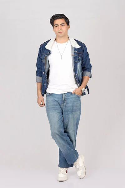 Beyaz arka planda poz veren yakışıklı İranlı genç adam.