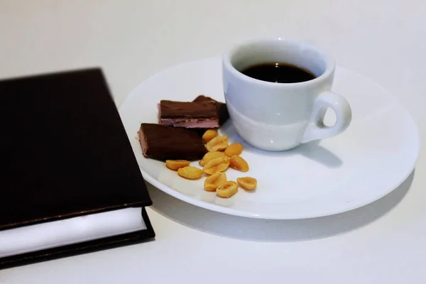 テーブルの上にナッツとチョコレートと朝のコーヒーカップ — ストック写真
