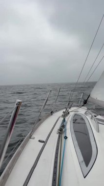 Bulutlu bir günde Baltık Denizi 'ni geçmek. Yelkenleri ve direkleri ince dalgalar ve karamsar deniz ışıklarıyla görmek.