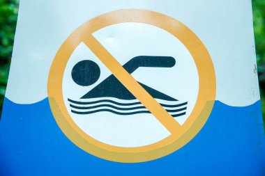Çapraz çizgili sarı bir çemberde yüzen bir kişinin piktogramıyla yüzmeyi yasaklayan bir uyarı işareti..