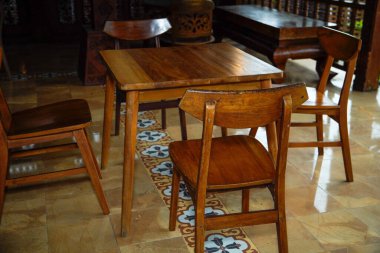 Kahverengi ahşap masa ve sandalyeler gölgeli kafeterya terasında..