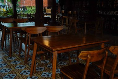 Kahverengi ahşap masa ve sandalyeler gölgeli kafeterya terasında..