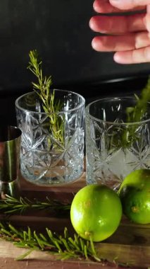 Rom, kola ve bardakta buzla yapılan nefis alkollü kokteyller geceleri dinlenmek ve yazın ferahlamak için. Baharat ve aroma için yeşil limon. Barmen ve bar.