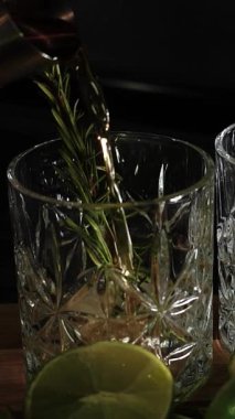 Rom, kola ve bardakta buzla yapılan nefis alkollü kokteyller geceleri dinlenmek ve yazın ferahlamak için. Baharat ve aroma için yeşil limon. Barmen ve bar.