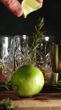 Rom, kola ve bardakta buzla yapılan nefis alkollü kokteyller geceleri dinlenmek ve yazın ferahlamak için. Baharat ve aroma için yeşil limon. Barmen ve bar.