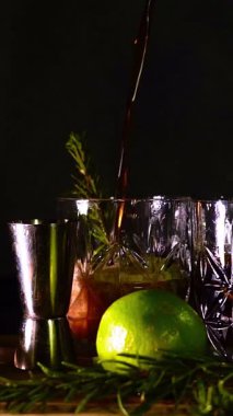 Rom, kola ve bardakta buzla yapılan nefis alkollü kokteyller geceleri dinlenmek ve yazın ferahlamak için. Baharat ve aroma için yeşil limon. Barmen ve bar.