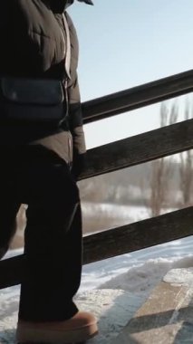 Açık havada bir kış parkında yürüyen güzel bir genç kadın. Soğuk, soğuk bir günde doğa parkında bir yürüyüş..