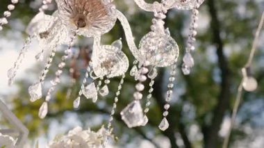 Cam bir avize ve güneş ışığında parlayan kristal bir avize. Güzel yansımalar ve ışınlar, bir ışık oyunu. Tören için düğün kemeri dekoru..