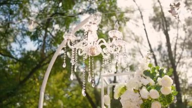 Cam bir avize ve güneş ışığında parlayan kristal bir avize. Güzel yansımalar ve ışınlar, bir ışık oyunu. Tören için düğün kemeri dekoru..