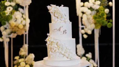 Akşam düğün kemeri beyaz çiçekler ve açık havada fenerlerle yeşillik. Resmî törende çiçek ve dekor. Kremalı büyük beyaz pasta.