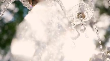 Cam bir avize ve güneş ışığında parlayan kristal bir avize. Güzel yansımalar ve ışınlar, bir ışık oyunu. Tören için düğün kemeri dekoru..