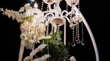 Cam bir avize ve güneş ışığında parlayan kristal bir avize. Güzel yansımalar ve ışınlar, bir ışık oyunu. Tören için düğün kemeri dekoru..