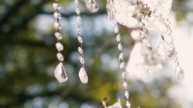 Cam bir avize ve güneş ışığında parlayan kristal bir avize. Güzel yansımalar ve ışınlar, bir ışık oyunu. Tören için düğün kemeri dekoru..