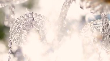 Cam bir avize ve güneş ışığında parlayan kristal bir avize. Güzel yansımalar ve ışınlar, bir ışık oyunu. Tören için düğün kemeri dekoru.