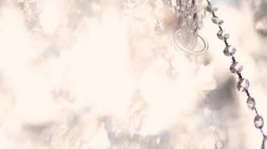 Cam bir avize ve güneş ışığında parlayan kristal bir avize. Güzel yansımalar ve ışınlar, bir ışık oyunu. Tören için düğün kemeri dekoru.