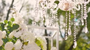 Cam bir avize ve güneş ışığında parlayan kristal bir avize. Güzel yansımalar ve ışınlar, bir ışık oyunu. Tören için düğün kemeri dekoru.