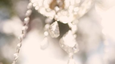 Cam bir avize ve güneş ışığında parlayan kristal bir avize. Güzel yansımalar ve ışınlar, bir ışık oyunu. Tören için düğün kemeri dekoru.