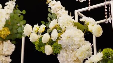 Akşam düğün kemeri beyaz çiçekler ve açık havada fenerlerle yeşillik. Resmî törende çiçek ve dekor. Kremalı büyük beyaz pasta.