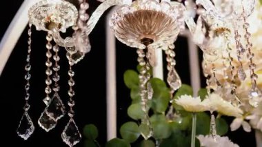 Cam bir avize ve güneş ışığında parlayan kristal bir avize. Güzel yansımalar ve ışınlar, bir ışık oyunu. Tören için düğün kemeri dekoru.